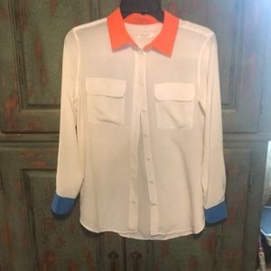 White silk blouse, orange collar, blue cuffs.